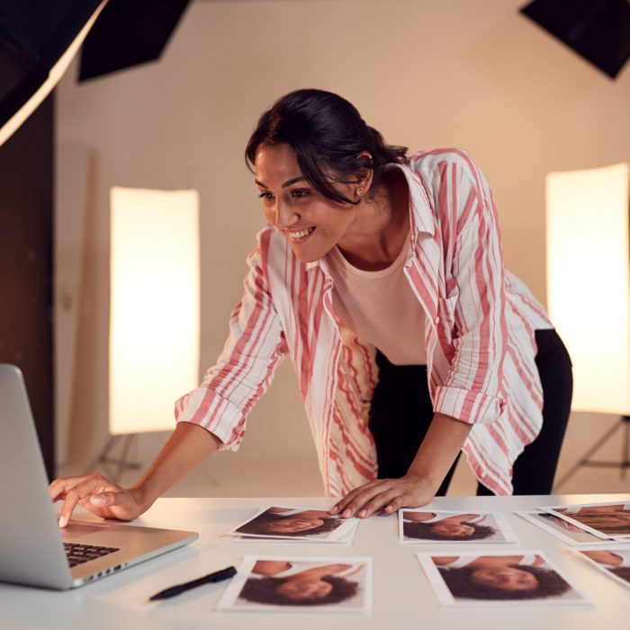 Female Photographer Editing Images From Photo Shoot In Studio